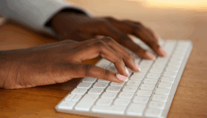 personne qui tape sur un clavier de mac
