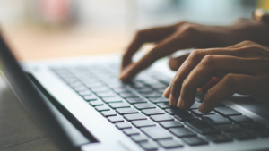 personne qui tape sur le clavier d'un ordinateur